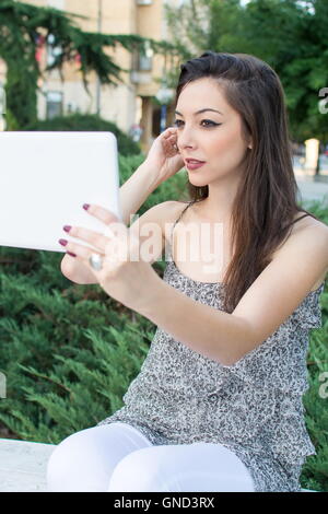 Junge Frau, die die Selfie mit einem Tablet-Gerät Stockfoto