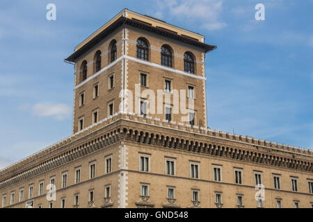 Der Außenseite des Gebäudes Assicurazioni Generali an der Piazza Venezia in Rom. Fassade aus Ziegeln, ungewöhnliche einen Turm gemacht. Blauer Himmel Stockfoto