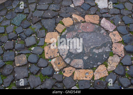 Dunkle Farbe der Steine mit einem kreisförmigen Detail in verschiedenen Farben. Stockfoto