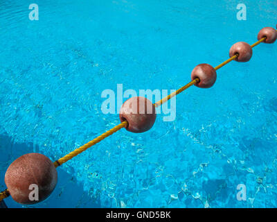 Diagonale Linie der Bojen auf dem Seil, teilt das Schwimmbad. Frische helle blaue Farbe des Wassers mit kleinen Wellen in der Stockfoto
