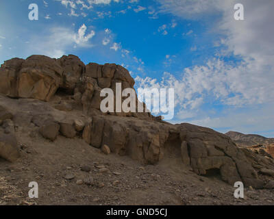 Abgerundete Ecken von den Felsen in der ägyptischen Wüste. Blauer Himmel mit intensiven weißen Wolken. Stockfoto