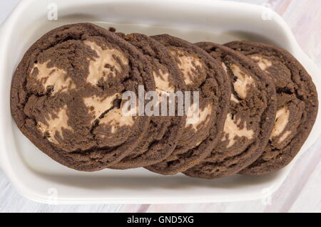 Braune Schokoladenkekse in eine Schüssel geben Stockfoto