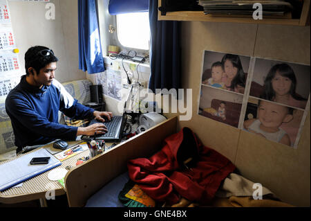 Deutschland Hamburg, philippinischer Seemann in seiner Kabine auf Frachtschiff MV Merwedijk im Hafen, Skypen mit Familie zu Hause in den Philippinen / DEUTSCHLAND Hamburg, Philipinnischer Seemann Auf Einem Schiff Im Hafen, Kommunikation Mit Familie im Internet Stockfoto