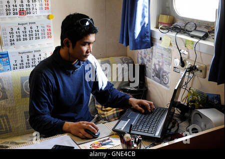 Deutschland Hamburg, philippinischer Seemann in seiner Kabine auf Frachtschiff MV Merwedijk im Hafen, Skypen mit Familie zu Hause in den Philippinen / DEUTSCHLAND Hamburg, Philipinnischer Seemann Auf Einem Schiff Im Hafen, Kommunikation Mit Familie im Internet Stockfoto