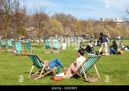 Menschen entspannend in der Frühlingssonne am Hyde Park, London, England, Großbritannien Stockfoto