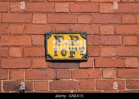 Eine alte Gusseisen Zeichen f.p. 10 ft. auf einer roten Backsteinmauer zeigt einen Hydranten 10 Fuß von der Wand-Fuß. Stockfoto