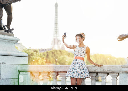 Paris, Frau tut ein Selbstporträt mit Eiffelturm im Hintergrund Stockfoto