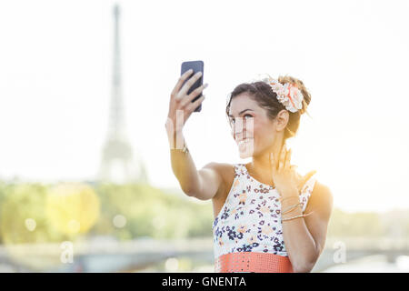 Paris, Frau tut ein Selbstporträt mit Eiffelturm im Hintergrund Stockfoto