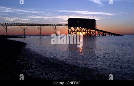 Die Sonne geht über der RNLI Lifeboat Station in Selsey, West Sussex. Stockfoto