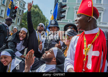 London, UK. 29. August 2016. Ein Polizist wird in den Geist mit einer Gruppe von "Nonnen" - strömen Menschenmassen um den 50. Notting Hill Carnival auf Bank Holiday Montag zu sehen. Bildnachweis: Guy Bell/Alamy Live-Nachrichten Stockfoto