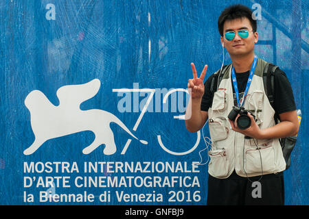 Venedig, Italien. 30. August 2016. Ein Journalist steht vor ein Zeichen der 73. Filmfestspiele von Venedig. Bildnachweis: Simone Padovani / Erwachen / Alamy Live News Stockfoto