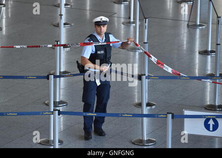 Frankfurt am Main, Deutschland. 31. August 2016. Ein Polizist erstreckt sich Absperrband im Abflugbereich des Flughafens Frankfurt in Frankfurt am Main, Deutschland, 31. August 2016. Am Mittwoch Vormittag Teile des Terminals 1 mussten evakuiert werden, weil eine Person laut Flughafenbetreiber Fraport den Sicherheitsbereich des Flughafens ohne üblichen Sicherheitsüberprüfungen erreicht hatte. Bildnachweis: Dpa picture Alliance/Alamy Live News Stockfoto