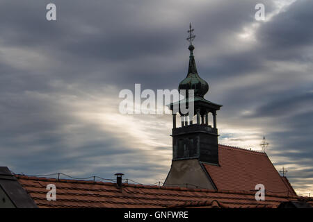 Kirche von St. Nikolaus in Bratislava, Slowakei. Frühe trüben regnerischen Morgen. Schwere dunkle Wolken gebrochen durch ein Sonnenschein. Dach in der f Stockfoto