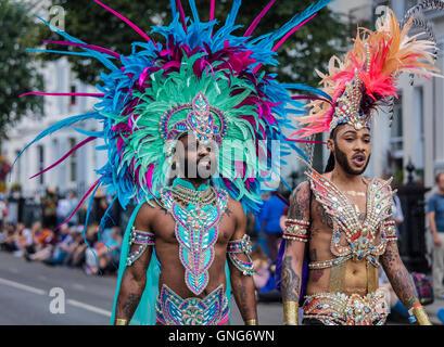 Zwei Männer in hell farbigen Kostümen gekleidet auf dem Notting Hill Carnival in Westlondon auf der Straße Stockfoto