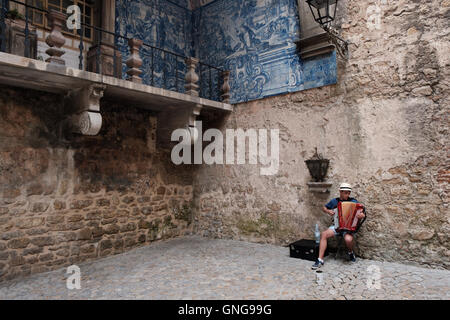 A Street Performer spielt Akkordeon und singt im Stadttor von Obidos, Portugal. Stockfoto