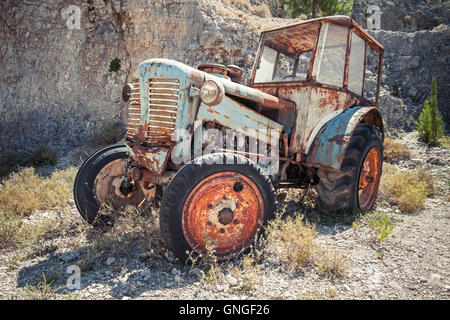 Alter verlassene verrosteter Traktor steht auf trockenen Sommer Rasen Stockfoto