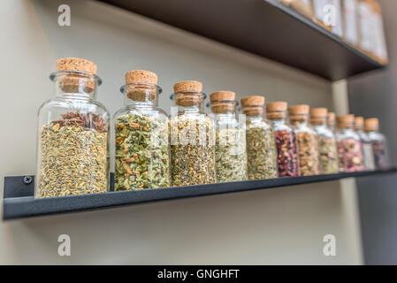 Flaschen mit Tee Zutaten auf Regal Stockfoto