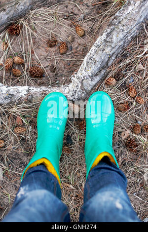 Nahaufnahme der Frau in Wellington Stiefel stehen im Wald Stockfoto