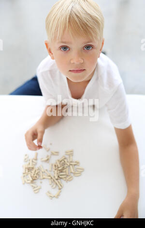 Glückliches Kind, spielerisch zu lernen. Vorschulkind Junge ordnet Puzzle. Stockfoto