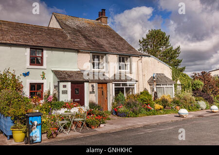 Ferienhäuser mit schönen Sommergarten und einen verzierten Mülleimer in Main Street, Ravenglass, Cumbria, England, UK Stockfoto