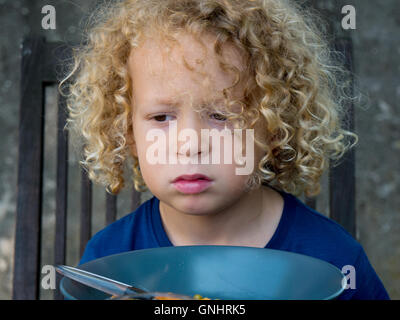 ein Junge, der sich weigert zu essen, draußen Stockfoto