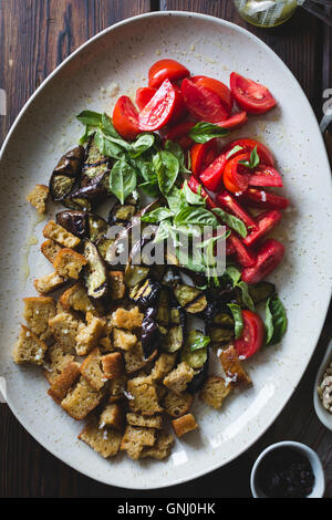 Aubergine Panzanella mit Kapern, Oliven und Pinienkerne, geröstet, glutenfrei. Stockfoto