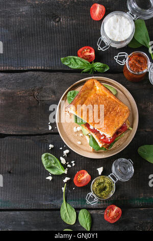 Low-Carb glutenfrei Cloud Brot vegetarischen Sandwich mit Spinat, Avocado, Feta Käse, Tomaten und Pesto-Sauce, serviert auf Platte w Stockfoto