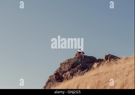 Vater und zwei Söhne auf Felsen sitzend, Mount Tamalpais, Kalifornien, Vereinigte Staaten Stockfoto