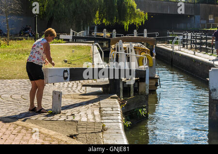 Eine Dame geschlossen eine Schleuse an der Kennet und Avon Kanal in Reading, Berkshire. Stockfoto