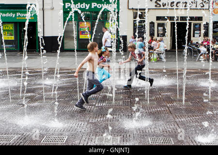 Kinder spielen in den pulsierenden Fontänen und Wasserstrahlen in Williamson Square, Liverpool, Merseyside, England Stockfoto