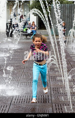Kinder spielen im Wasser mit Brunnen und Wasserstrahlen in der Williamson Square, Liverpool, Merseyside, UK Stockfoto