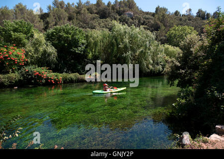 Junge, Paddeln im Kajak entlang des Flusses Sorgue mit kristallklarem Wasser während der Freizeitbeschäftigung. Kind und Sommer sport Stockfoto