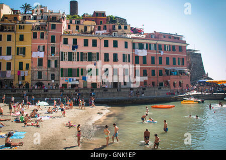 VERNAZZA, Italien - Juli 2016: Menschen am Strand von der gemütlichen Stadt Vernazza Cinque Terre in Italien Stockfoto