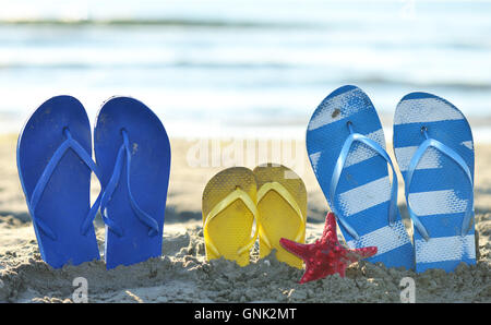 Farbe Flip Flops am Sandstrand am Meer Stockfoto