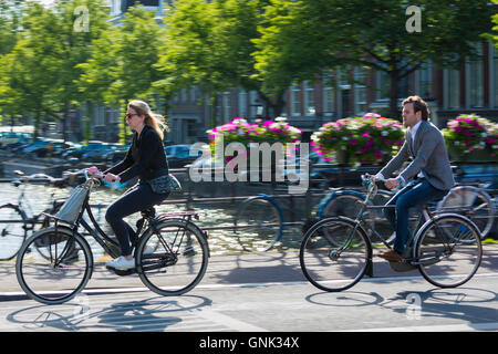 Junge Menschen in Freizeitkleidung Radfahren über Brücke in Amsterdam, Holland Stockfoto