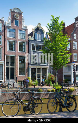 Radfahrer, Fahrräder und Canalside Giebel Häuser - holländischen Giebeln auf Brouwersgracht in Amsterdam, Holland Stockfoto