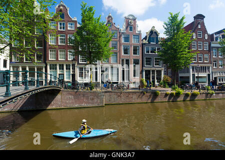 Touristische Kayakking im Einerkajak durch Canalside Giebel Häuser - holländische Giebel - auf Brouwersgracht in Amsterdam, Holland Stockfoto