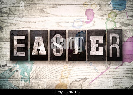 Das Wort "Ostern" in Vintage, schmutzige Metall Buchdruck Typ auf einem weiß getünchten hölzernen Hintergrund mit Tinte und Farbe Flecken geschrieben. Stockfoto