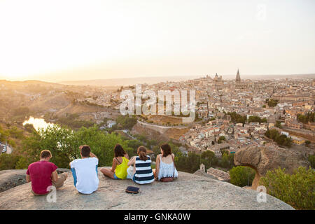 Toledo, Spanien – 27. Juli 2016: Junge Leute sitzen auf dem Stein genießen ruhigen magischen Moment des Sonnenuntergangs über Toledo Stadt, Spai Stockfoto