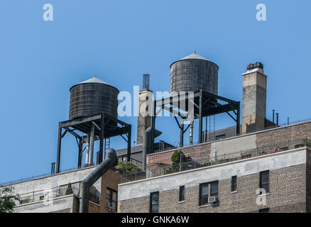 Alte hölzerne Wassertanks auf Dächern auf New York City Wohn Gebäude. Stockfoto