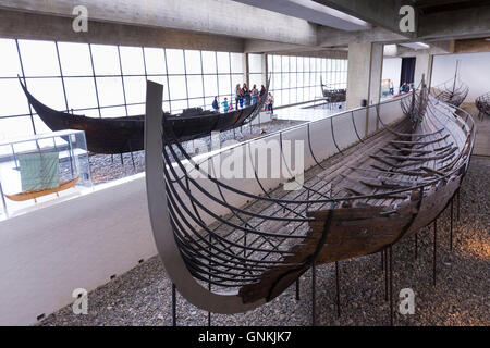 Touristen sehen Sculdelev original Longboat-Ausstellung im Wikingerschiffsmuseum Roskilde in Seeland, Dänemark Stockfoto