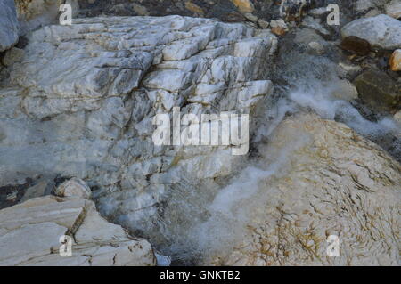 Wasser fließt zwischen Felsen Stockfoto