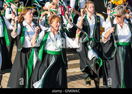 Broadstairs Folk Woche Festival. Offcumduns Damen Morris Gruppe in ihrem grünen und schwarzen Kostümen, kleine Stäbchen wie Sie tanzen im Freien. Stockfoto