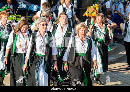 Broadstairs Folk Woche Festival. Offcumduns Damen Morris Gruppe in ihrem grünen und schwarzen Kostümen, kleine Stäbchen wie Sie tanzen im Freien. Stockfoto