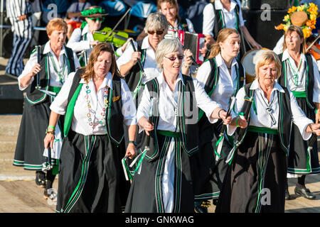 Broadstairs Folk Woche Festival. Offcumduns Damen Morris Gruppe in ihrem grünen und schwarzen Kostümen, kleine Stäbchen wie Sie tanzen im Freien. Stockfoto