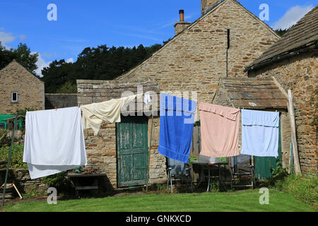 Wäsche zum Trocknen auf eine Wäscheleine an einem sonnigen Tag draußen hängen Stockfoto