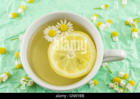 Kamillentee mit Zitronenscheiben und Blumen Stockfoto