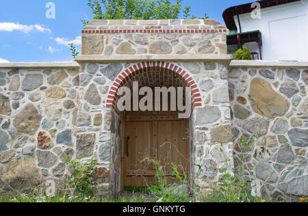 Neues Holz Tor in Stein Gartenmauer. Stockfoto