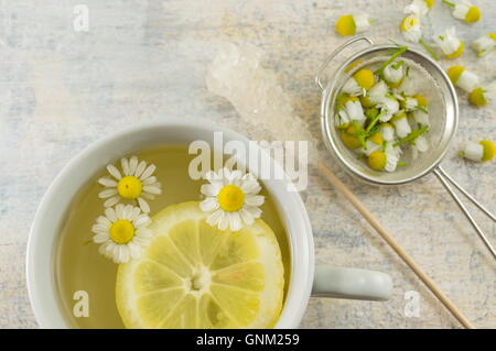 Kamillentee mit Zitronenscheiben und Blumen Stockfoto