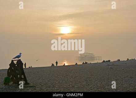 Strand, Meer und alten stillgelegten West Pier in Brighton, East Sussex, England im Meer Nebel, am späten Nachmittag. Mit Menschen am Strand Stockfoto